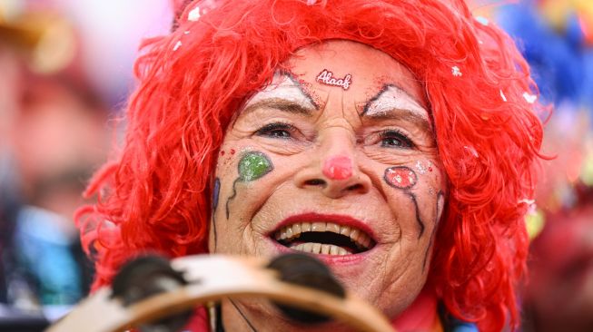 Seorang pengunjung merayakan dimulainya musim Karnaval musim karnaval "kelima" atau karnaval konyol di Cologne, Jerman, Jumat (11/11/2022). [INA FASSBENDER / AFP]