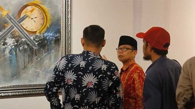 Kepala Galeri Hang Nadim (GHN), Furqon Elwe menjelaskan ke pengunjung pameran seni rupa JEDA di Anjungan Kampar Kompleks Bandar Seni Ali Haji (Bandar Serai) atau purna MTQ Jalan Sudirman Pekanbaru.