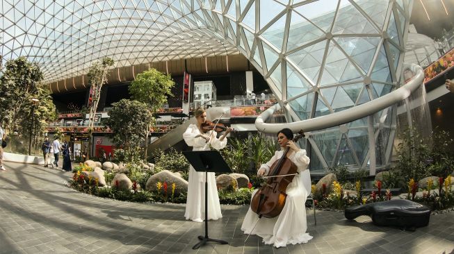 Musisi tampil di taman tropis yang ada di Bandara Internasional Hamad, Doha, Qatar, Kamis (10/11/2022). [KARIM JAAFAR / AFP]
