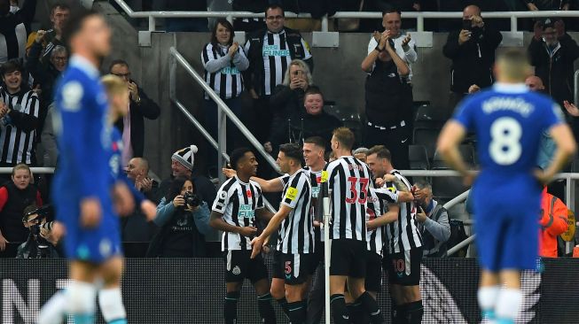 Gelandang Newcastle United Joe Willock merayakan golnya usai mencetak gol pertama timnya dengan rekan satu tim selama pertandingan sepak bola Liga Premier Inggris antara Newcastle United melawan Chelsea di St James 'Park, Minggu (13/11) dini hari WIB. [AFP Photo]
