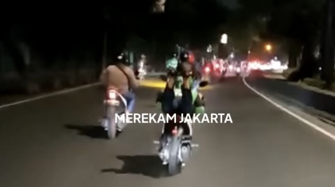 Viral Ugal-ugalan di Jalan, Pria Beratribut Ojol Pamer Lepas Tangan sampai Tiduran Bak Superman