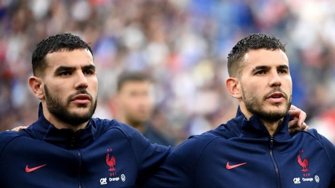 Bek Prancis Lucas Hernandez (kanan) dan Theo Hernandez menyanyikan lagu kebangsaan menjelang pertandingan sepak bola UEFA Nations League - Liga A Grup 1 antara Prancis dan Denmark di Stade de France di Saint-Denis, utara Paris, pada 3 Juni.  , 2022. FRANCK FIFE / AFP.