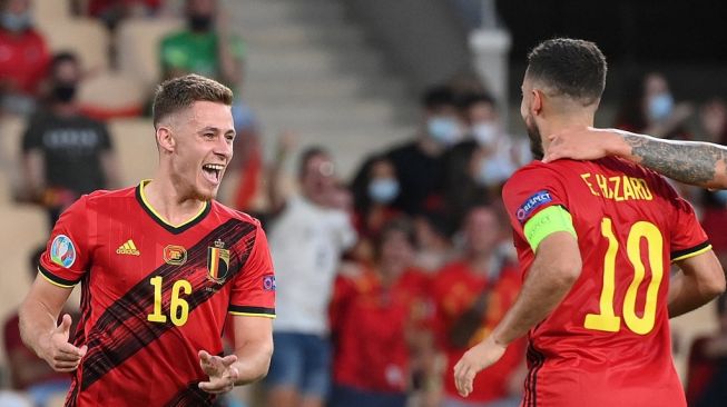 Gelandang Timnas Belgia Thorgan Hazard (kiri) merayakan gol pembuka dengan kakaknya, Eden Hazard selamalaga babak 16 besar UEFA EURO 2020 antara Belgia vs Portugal di Stadion La Cartuja di Seville pada 27 Juni 2021.GEN LLUIS / KOLAM / AFP.