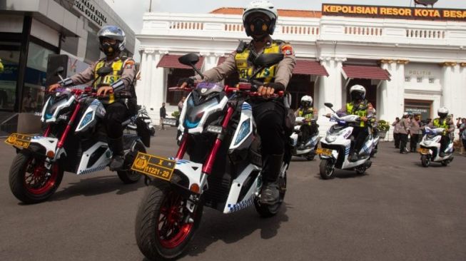 Petugas polisi mengikuti apel penerimaan hibah sebanyak 20 unit kendaraan listrik roda dua untuk operasional dari sejumlah pengusaha yang mewakili masyarakat di halaman Markas Polrestabes Surabaya, Selasa (15-11-2022) [ANTARA/Didik Suhartono].