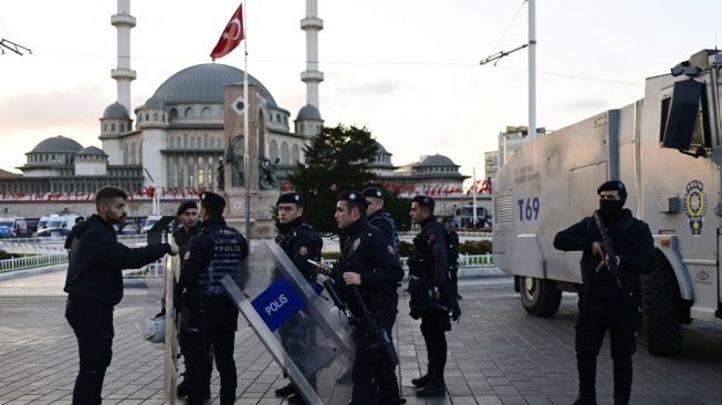 Polisi Turki mencoba mengamankan daerah itu setelah ledakan kuat mengguncang jalan perbelanjaan Istiklal, pada Minggu (13/11/2022). [Yasin AKGUL / AFP]