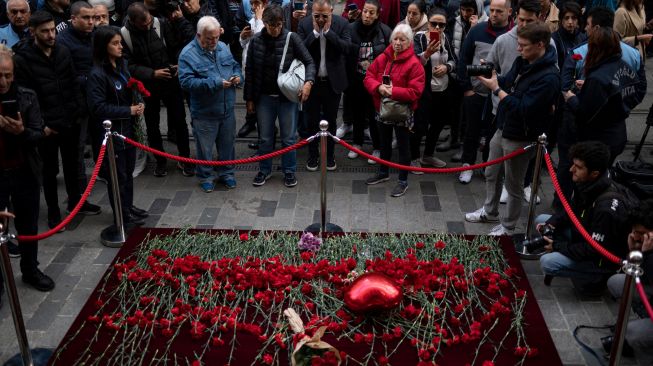 Para pelayat berduka untuk para korban di lokasi ledakan bom di Jalan Istiklal, Istanbul, Turki, Senin (14/11/2022). [Yasin AKGUL/AFP]