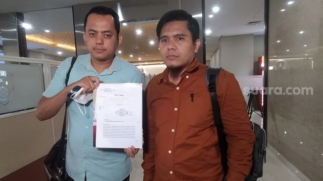 Kuasa Hukum korban robot trading Net89, Zainul Arifin (kanan) menunjukan surat SP2AP usai melakukan pelaporan di Bareskrim Polri, Jakarta, Selasa (15/11). [Suara.com/Oke Atmaja]