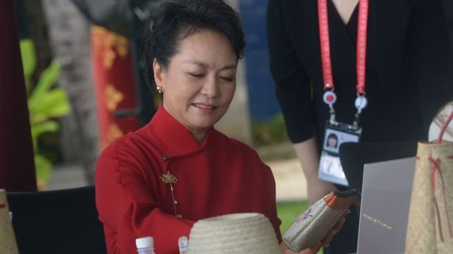 Ibu Negara China Peng Liyuan mewarnai kerajinan anyaman saat Spouse Program KTT G20 di Nusa Dua, Badung, Bali, Selasa (15/11/2022). [ANTARA FOTO/Media Center G20 Indonesia/Zabur Karuru/nym].