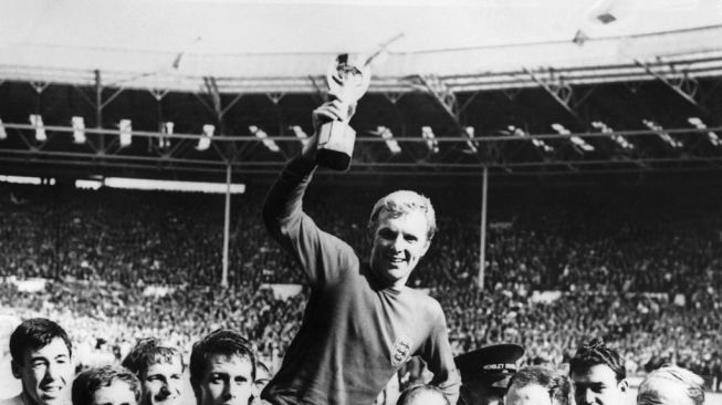 Kapten timnas Inggris Bobby Moore mengangkat tinggi-tinggi trofi Jules Rimet saat ia diangkat oleh rekan satu timnya menyusul kemenangan Inggris atas Jerman (4-2 di perpanjangan waktu) di final Piala Dunia 30 Juli 1966 di stadion Wembley di London.CENTRAL PRESS / AFP