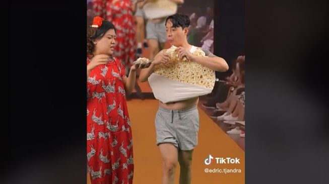 Edric Tjandra fashion show sambil makan kerupuk raksasa. (TikTok/edric.tjandra)