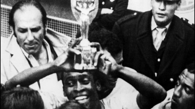 Penyerang Brasil Pele tersenyum saat ia memegang Piala Jules Rimet setelah Brasil mengalahkan Italia 4-1 di final Piala Dunia 1970 di Mexico City pada 21 Juni 1970. [STF / AFP]