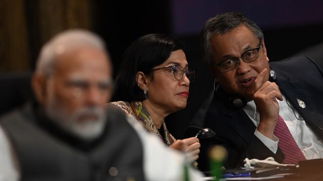 ubernur Bank Indonesia Perry Warjiyo (kanan) berbincang dengan Menteri Keuangan Sri Mulyani Indrawati (tengah) saat sesi intervensi KTT G20 di Nusa Dua, Bali, Selasa (15/11/2022). [ANTARA FOTO/Media Center G20 Indonesia/Prasetyo Utomo/nym].