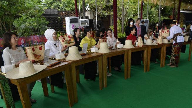 Ibu Negara Indonesia Iriana Joko Widodo (keempat kiri) bersama (dari kiri ke kanan) Istri Perdana Menteri Jepang Yuko Kishida, Ibu Negara Turki Emine Erdogan, Ibu Negara Korea Selatan Kim Keon-hee, Ibu Negara China Peng Liyuan, dan Istri Perdana Menteri Spanyol Maria Begona Gomez mewarnai kerajinan anyaman saat Spouse Program KTT G20 di Nusa Dua, Badung, Bali, Selasa (15/11/2022). [ANTARA FOTO/Media Center G20 Indonesia/Zabur Karuru/nym].