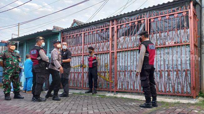 Sejumlah aparat berjaga saat olah TKP kasus penemuan satu keluarga yang meninggal dunia di Komplek perumahan Citra Garden 1 Extencion Kalideres Jakarta Barat, Rabu (16/11/2022) ini. [Suara.com/Yaumal] 