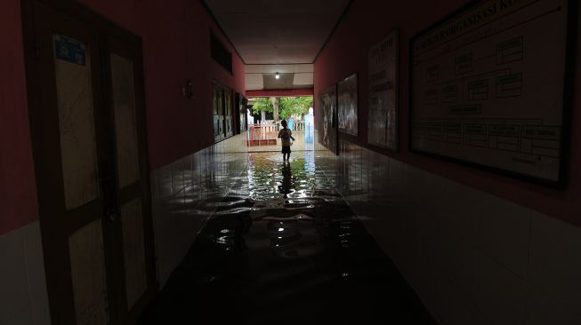 Seorang anak melintas di lorong sekolah yang terendam banjir di Sekolah Dasar Negeri 2 Krakitan, Bayat, Klaten, Jawa Tengah, Rabu (16/11/2022). [ANTARA FOTO/Aloysius Jarot Nugroho/foc].