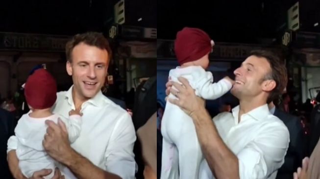 Presiden Prancis Emmanuel Macron menggendong bayi warga Bali. [Instagram @infokomando.official]