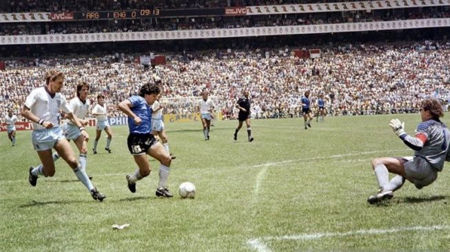 Diego Armando Maradona mengecoh bek Inggris Terry Butcher saat menggiring bola yang kemudian melewati hadangan kiper Peter Shilton ketika menciptakan gol kedua ke gawang Inggris dalam pertandingan Piala Dunia 1986 di Mexico City pada 22 Juni 1986 yang Argentina menang 2-1 dan salah satu gol lainnya dicetak Maradona yang kemudian dikenal dengan gol tangan Tuhan. ANTARA/AFP/STAFF/aa.