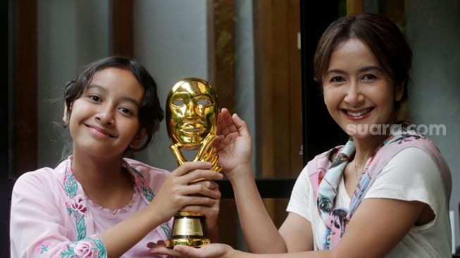 Widuri Putri Sasono bersama ibundanya Widi Mulia menunjukan piala IMMA Awards 2022 di Jakarta, Kamis (17/11). [Suara.com/Oke Atmaja]