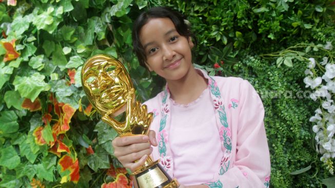  Widuri Putri Sasono, anak kedua pasangan Dwi Sasono dan Widi Mulia menunjukan piala IMMA Awards 2022 di Jakarta, Kamis (17/11). [Suara.com/Oke Atmaja]