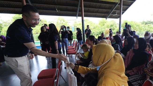 
Ramesh Divyanathan President Director BMW Group Indonesia membagikan bingkisan kepada warga Rorotan Indah, Jakarta, Rabu (17/11). [Suara.com/Oke Atmaja]