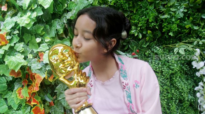  Widuri Putri Sasono, anak kedua pasangan Dwi Sasono dan Widi Mulia menunjukan piala IMMA Awards 2022 di Jakarta, Kamis (17/11). [Suara.com/Oke Atmaja]