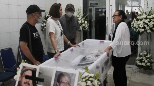 Aktor Ray Sahetapy kanan bersama Rowiena Umboh tengah berbincang dengan Istri Rudis Salam,  Marina Garden disamping peti jenazah, Jakarta, Jumat (18/11). [Suara.com/Oke Atmaja]