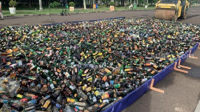 Pemprov DKI Jakarta melakukan pemusnahan 14.477 botol miras ilegal dan oplosan di Silang Monas Sisi Tenggara, Jumat (18/11/2022). [Suara.com/Fakhri Fuadi Muflih]