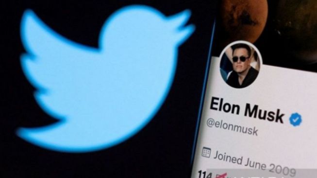 Akun twitter Elon Musk terlihat pada smartphone di depan logo Twitter. (ANTARA/REUTERS/Dado Ruvic/am)