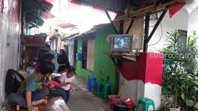 Sejumlah anak-anak di Bukit Duri, Jakarta Selatan, berkumpul di Pos Kamling untuk nonton televisi buntut dari harga STB mahal, Jumat (18/11/2022). [Suara.com/Yosea Arga Pramudita]