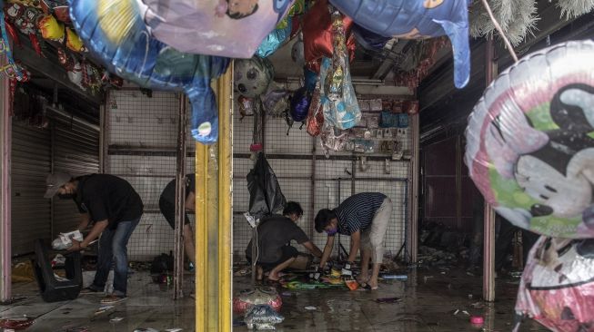 Pemilik kios menyelamatkan barang dagangannya saat kebakaran melanda pertokoan Pasar Pagi Asemka di Jakarta Barat, Jumat (18/11/2022). [ANTARA FOTO/Muhammad Adimaja/rwa]