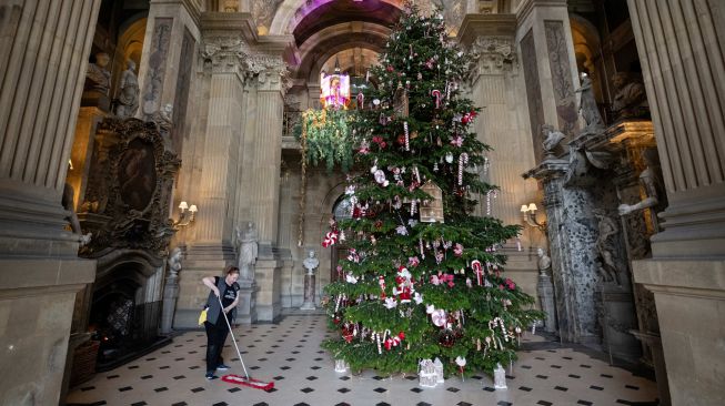 Seorang anggota staf membersihkan pajangan Natal di Castle Howard, Malton, Inggris, Jumat (11/11/2022). [OLI SCARFF/AFP]