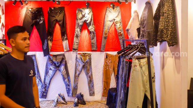 Pengunjung melihat produk-produk denim yang dipajang dalam pameran Wall of Fades di Pondok Indah Mall (PIM) 3, Jakarta Selatan, Sabtu (19/11/2022). [Suara.com/Alfian Winanto]