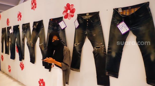 Pengunjung melihat produk-produk denim yang dipajang dalam pameran Wall of Fades di Pondok Indah Mall (PIM) 3, Jakarta Selatan, Sabtu (19/11/2022). [Suara.com/Alfian Winanto]