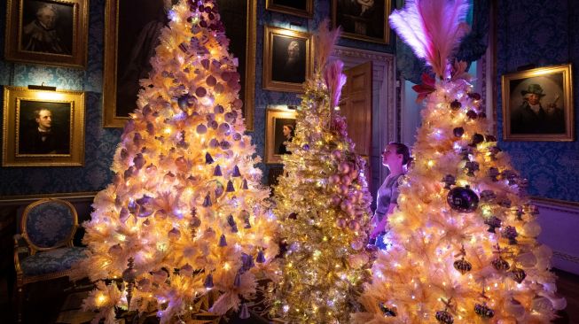 Seorang anggota staf mengagumi pajangan Natal di Castle Howard, Malton, Inggris, Jumat (11/11/2022). [OLI SCARFF/AFP]