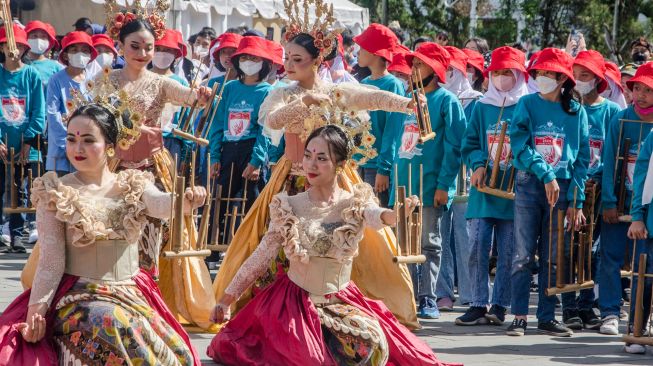 Penari mementaskan tarian dengan alat musik angklung secara bersama di halaman Gedung Sate, Bandung, Jawa Barat, Minggu (20/11/2022). [ANTARA FOTO/Novrian Arbi/nz]
