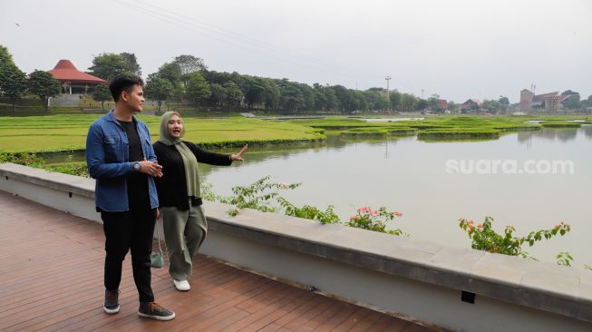 Pengunjung melihat pemandangan di Danau Archipelago di Taman Mini Indonesia Indah (TMII), Jakarta Timur, Minggu (20/11/2022). [Suara.com/Alfian Winanto]