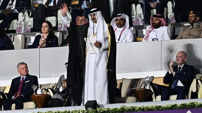 Emir Qatar Sheikh Tamim bin Hamad al-Thani (tengah) melambai sebelum menyampaikan pidato di samping Raja Abdullah II dari Yordania (kiri) dan Presiden FIFA Gianni Infantino selama upacara pembukaan Piala Dunia 2022 antara Qatar vs Ekuador di Stadion Al-Bayt di Al Khor, utara Doha pada 20 November 2022.MANAN VATSYAYANA / AFP.