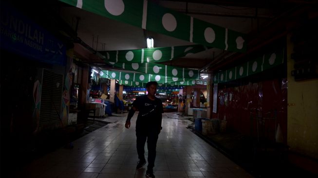 Warga melewati deretan bendera partai politik Partai Islam Se-Malaysia (PAS) di Pasar Siti Khadijah, Kota Bharu, Kelantan, Malaysia, Sabtu (19/11/2022). [ANTARA FOTO/ Rafiuddin Abdul Rahman/rwa]