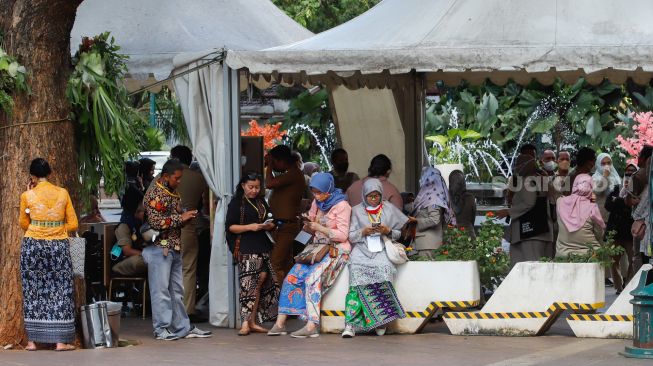 Sejumlan ASN di Balai Kota berkumpul di lapangan pasca gempa di Jakarta, Senin (21/11/2022). [Suara.com/Alfian Winanto]
