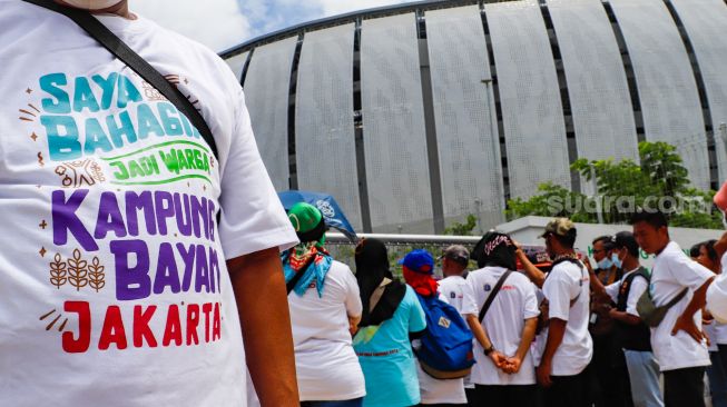 Warga berunjuk rasa di depan gerbang Kampung Susun Bayam, Jakarta Utara, Senin (21/11/2022). [Suara.com/Alfian Winanto]