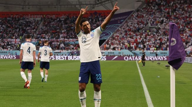 Gelandang Timnas Inggris, Jude Bellingham melakukan selebrasi usai mencetak gol ke gawang Iran pada laga Piala Dunia 2022 di Qatar, Senin (21/11/2022) malam WIB. [Adrian DENNIS / AFP]