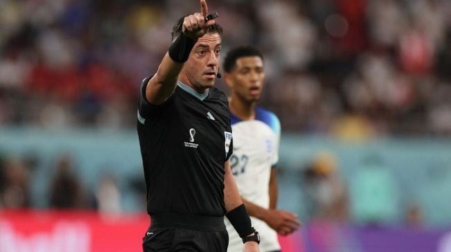 Wasit asal Brasil, Raphael Claus memimpin laga Piala Dunia 2022 antara Timnas Inggris vs Iran. [Adrian DENNIS / AFP]