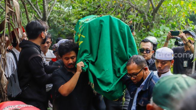 Keluarga dan pelayat membawa keranda jenazah Agung Yulianto alias Ki Joko Bodo untuk dimakamkan di TPU Kober, Lubang Buaya, Jakarta Timur, Selasa (22/11/2022). [Suara.com/Alfian Winanto]