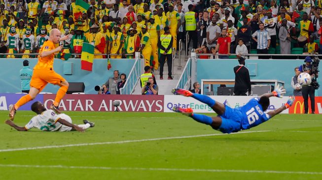 Gelandang Belanda Davy Klaassen (kiri) mencetak gol melewati kiper Senegal Edouard Mendy saat pertandingan sepak bola Grup A Piala Dunia 2022 antara Senegal dan Belanda di Stadion Al-Thumama di Doha, Qatar, Senin (21/11/2022). [Odd ANDERSEN / AFP]
