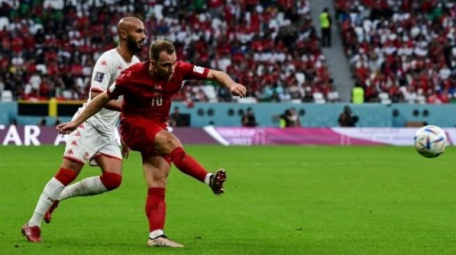 Pemain Denmark Christian Eriksen (kiri) melepaskan tendangan ke gawang Tunisia dalam pertandingan Grup D Piala Dunia 2022 di Educational City Stadium, Qatar, Selasa (22/11/2022). [AFP]