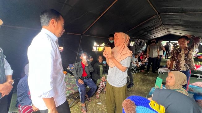 Presiden Joko Widodo atau Jokowi memberikan bantuan kepada salah satu pengungsi terdampak gempa Cianjur, Jawa Barat, Selasa (22/11/2022), (Laily Rachev - Biro Pers Sekretariat Presiden)