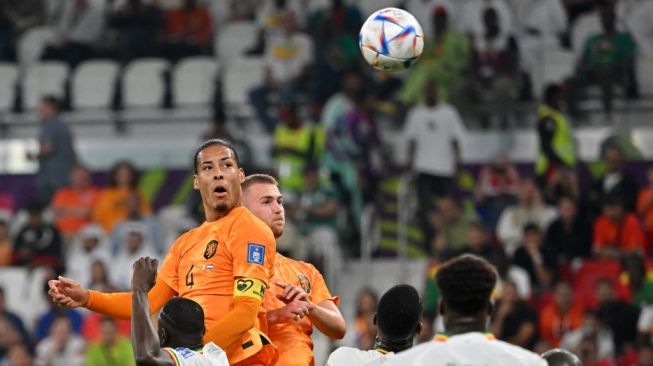 Bek Timnas Belanda #04 Virgil Van Dijk menyundul bola selama matchday pertama Grup A Piala Dunia 2022 antara Senegal vs Belanda di Stadion Al-Thumama di Doha pada 21 November 2022.Alberto PIZZOLI / AFP