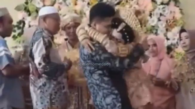 Tangkapan layar video viral pengantin wanita peluk pria lain di atas pelaminan. [TikTok]