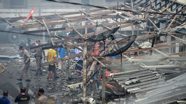 Petugas kepolisian dan petugas penyelamat memeriksa kerusakan setelah bom mobil meledak di kota Narathiwat, Thailand, Selasa (22/11/2022). [Madaree TOHLALA / AFP]