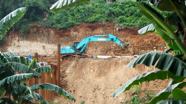 Pekerja menyelesaikan proyek Pembangunan Sistem Pengambilan dan Treatment Sampah Badan Air melalui Rekayasa Sungai pada Kali Ciliwung segmen TB Simatupang di kawasan Kampung Gedong, Pasar Rebo, Jakarta Selatan, Rabu (23/11/2022). [Suara.com/Alfian Winanto]